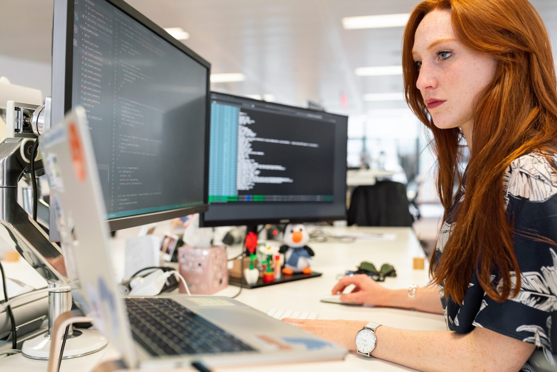 Image of a woman sitting at a desk and coding – technical skills are also important for building teams that thrive.