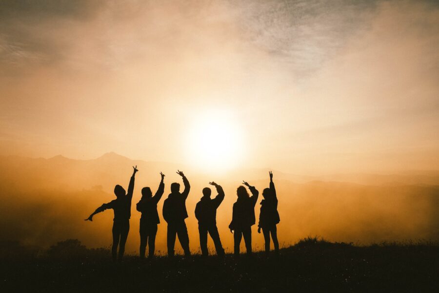 Photo of a six people looking happy watching a sunset